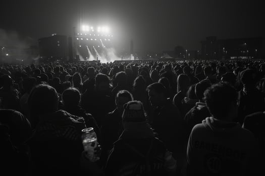 A vast audience gathers under bright stage lights at night, enjoying a live performance in a bustling city atmosphere photo