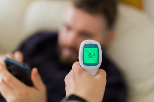 Close up of infrared digital forehead thermometer in hand,fever examination and measures to prevent and screen people check body temperature during its reopening after COVID-19 Coronavirus Lockdown photo