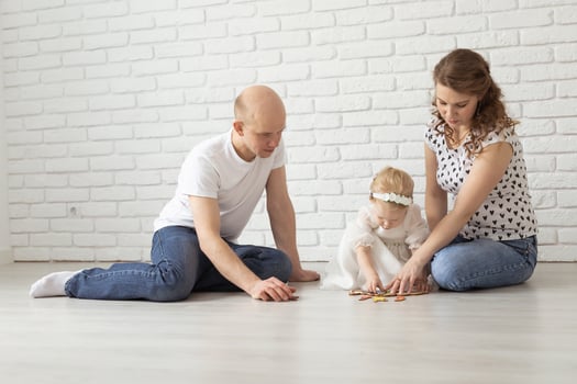 Baby child with hearing aids and cochlear implants plays with parents on floor. Deaf and rehabilitation concept photo