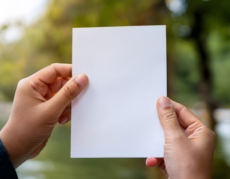 Person Holding Plain Paper with Bokeh Background photo