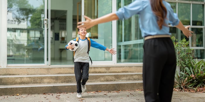 Celebrating Arrival and Connection. A child joyfully runs to greet a parent after school, showcasing love and support. photo