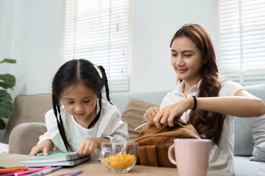 Learning and Family Bonding. A mother helps her daughter organize school supplies at home. photo