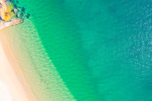 aerial beach serenity sand meets turquoise water pastel beach scene soft hues of sand and ocean, aerial drone top down view photo