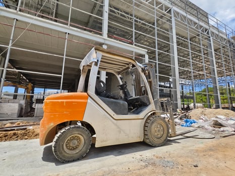 A forklift is parked in front of a building under construction photo