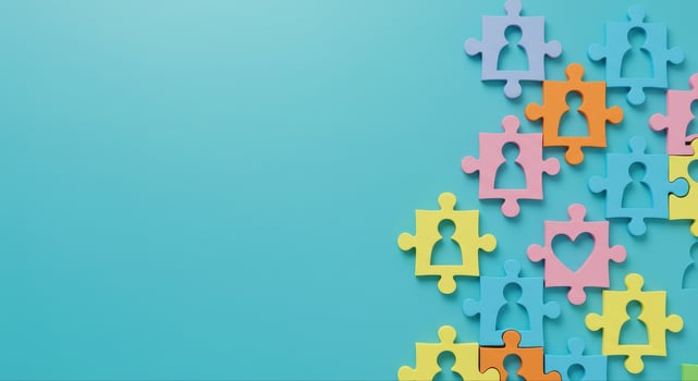 Colorful Puzzle Pieces Forming Human and Heart Shapes on a Blue Background photo