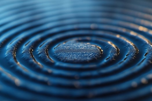 Close-up of concentric water ripples on a blue surface, creating a serene and calming effect. photo