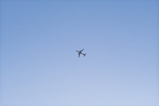 A large airplane is flying in the sky above a clear blue sky photo
