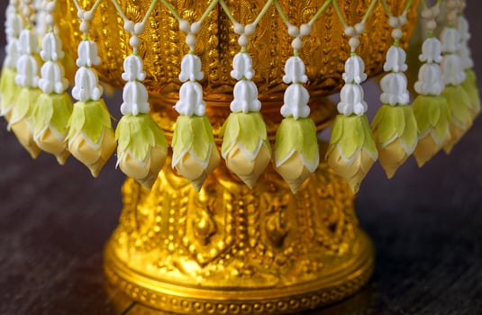 Uba is a flower that is strung in a string and attached to a bunch like a tassel for hanging on a tray with a pedestal or a flower garland. photo