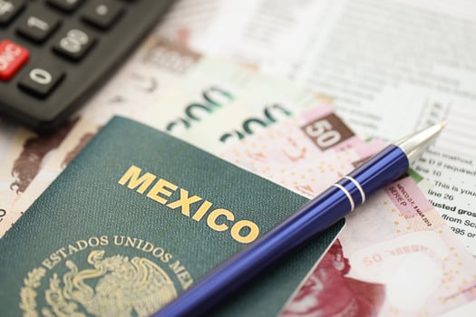 Mexican pesos money in big amount lies on table with pen, calculator, passport and tax forms photo