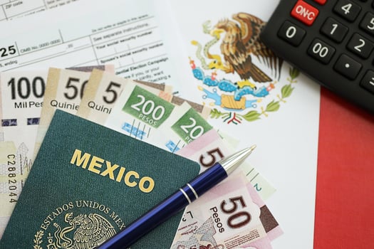 Mexican pesos money bills in big amount on table with pen, calculator, passport and tax forms photo