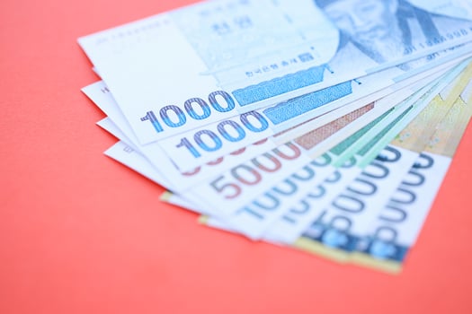 South Korean money in big amount lies on red color table photo