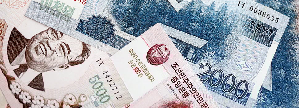 North Korean won money bills in big amount lies on white color table close up photo