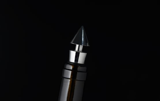 Elegant metallic pen tip shines against a dark background, showcasing exquisite craftsmanship and design in a close-up perspective photo