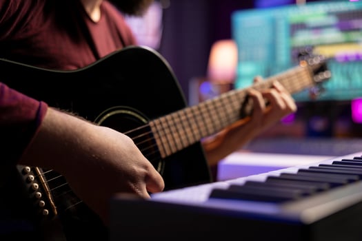 Young artist playing guitar and creating music using daw software interface on computer, recording audio files. Musician composing songs in home studio and mixing acoustic sounds. Close up. photo