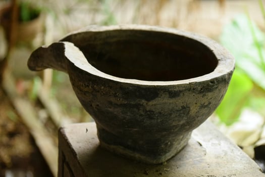 Antique earthenware pot with spout on dark background photo