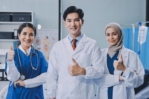 Asian doctor giving thumbs up to his colleagues photo