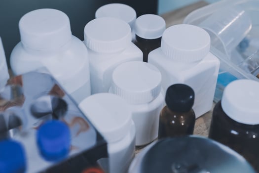 Many different types of medicine bottles are on a table photo