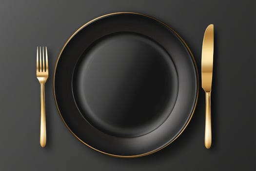 Elegant black plate with golden fork and knife, a stylish and luxurious table setting perfect for fine dining photo