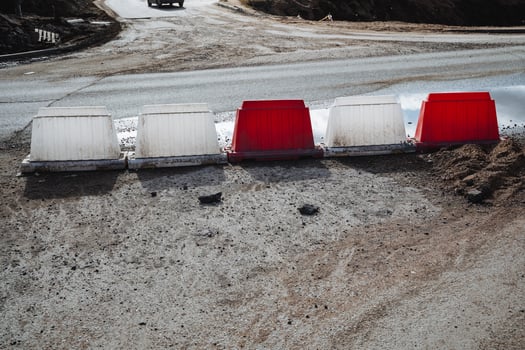 A long, continuous row of red and white barriers placed strategically along the side of a busy road, providing a visual indication of designated areas or potential hazards ahead photo