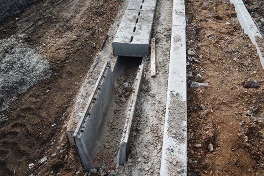 A concrete drain is currently under construction in the dirt, which is an essential part of the infrastructure being set up for various purposes such as agriculture and drainage photo