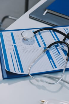 A stethoscope and medical papers on a desk photo