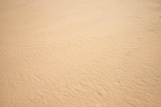 Fine beach sand smooth texture in summer sun close up photo. Nice beige background for your projects photo
