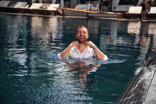 Handsome man in formal ,clothes is in the pool photo