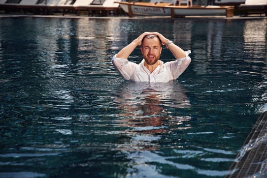 Handsome, man in formal clothes is in the pool photo