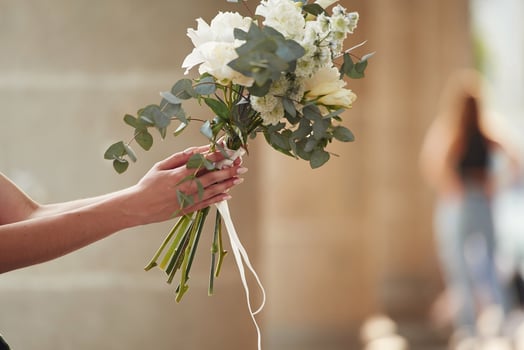 Close up view of flowers in hand., Woman is outdoors photo