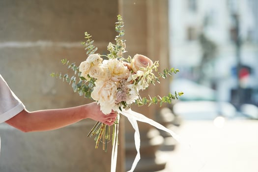 City,, at background. Close up view of woman that is with flowers in hands photo