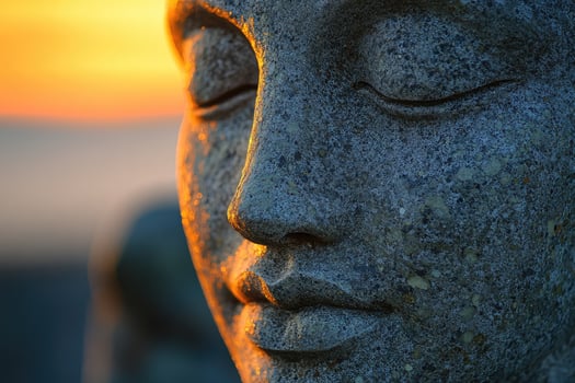 A stone statue of a buddha with its eyes closed photo