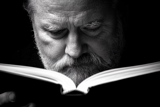 A man with a beard reading a book photo