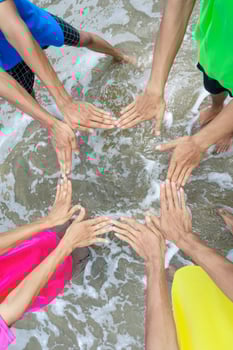 Hands United in a Circle on the Water's Edge photo