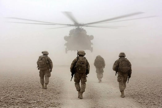 Soldiers walk towards a helicopter in the fog photo