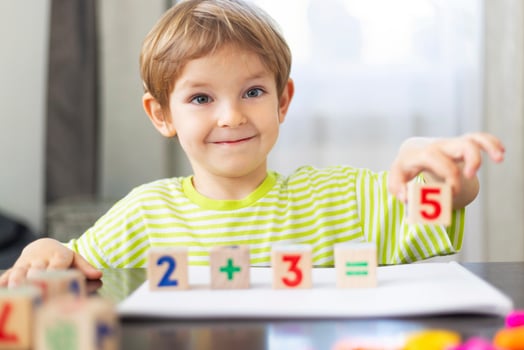Smiling child learning math with blocks photo