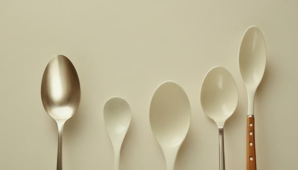 A group of four spoons and a spoon on a white surface photo