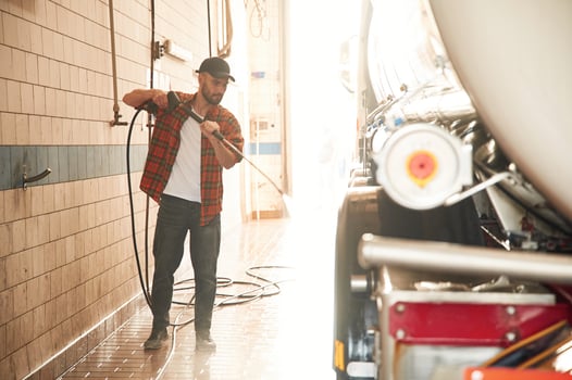 Standing, and ,washing the vehicle. Young truck driver in casual clothes photo