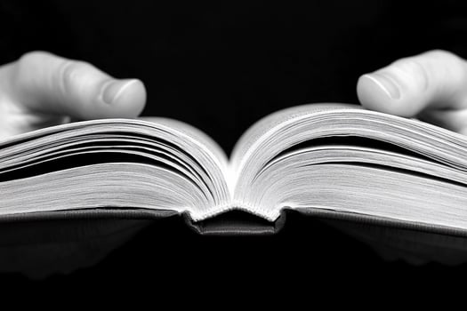 A person holding an open book in their hands photo