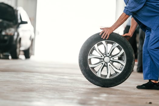 Walking ,with, new ,tire. Auto mechanic working in garage. Repair service photo