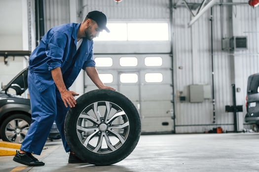 New, tire, moving it. Auto mechanic, working in garage. Repair service photo
