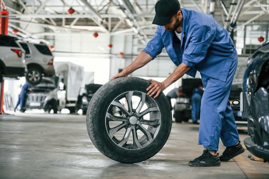 New, tire, movingm it. Auto mechanic working in garage. Repair service photo