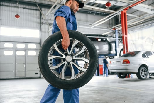 With, brandm new wheel. Auto mechanic working in garage. Repair service photo