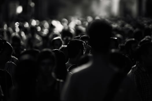 A large crowd fills the urban environment, captured in black and white, highlighting the diversity and anonymity of the people photo