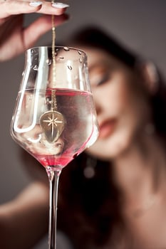 Drops of red blood paint in glass of water, a woman looks at the glass. photo