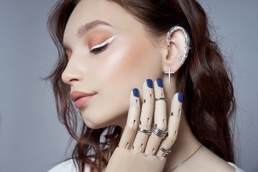 Beauty portrait of woman with natural makeup and painted polished nails on her hand. Rings on fingers of the hand photo
