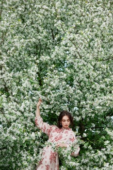 Woman with natural makeup, floral cosmetics for skin of face, girl posing in flower branches of blooming apple tree in spring photo