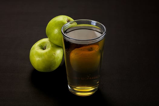 A glass of apple juice and a bunch of green apples photo