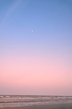 View over the beach on the coast of Usedom at sunset. The moon is in the sky. photo