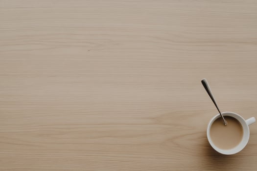 Coffee cup and spoon on wooden table photo