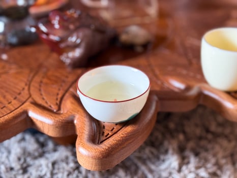 Ceramic tea cup placed with care during traditional tea gathering. Quiet beauty of a tea ceremony and its meditative atmosphere. photo